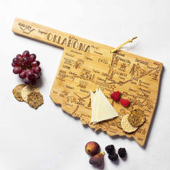 Introducing the Destination Oklahoma Cutting Board by Totally Bamboo, a beautifully crafted state-shaped board made from bamboo. Elegantly designed in the shape of Oklahoma with laser-engraved city names, this decorative yet functional piece is perfect for holding cheese slices, crackers, grapes, and figs on its smooth surface. A stylish addition to any kitchen collection.