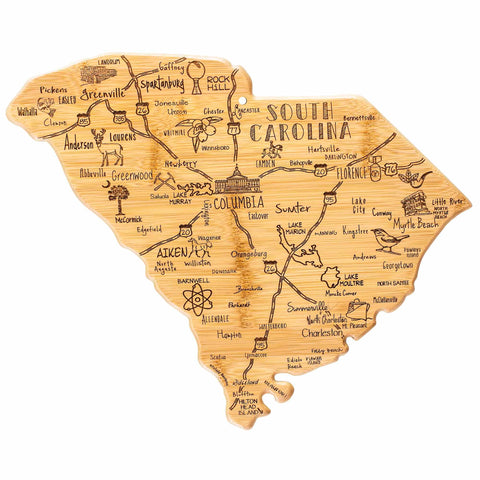 The "Destination South Carolina Cutting Board" by Totally Bamboo, measuring 14" x 11.5", showcases a wooden map of South Carolina with laser-engraved, hand-drawn illustrations and labels. It highlights cities such as Charleston, Columbia, Greenville, and Myrtle Beach along with state symbols and notable landmarks.