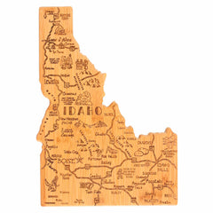 This Destination Idaho Cutting Board by Totally Bamboo, measuring 15" x 10-1/2", features laser-engraved artwork that highlights city names, major highways, and natural landmarks such as Boise and Twin Falls on a wooden map of Idaho. The intricate detailing truly captures the geographical features and notable locations, making it an ideal addition to any bamboo cutting surface.