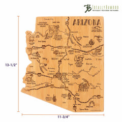 The Totally Bamboo Destination Arizona Cutting Board, measuring 13-1/2" x 11-3/4", is crafted from bamboo and shaped like the state of Arizona. It features laser-engraved artwork with city names and landmarks such as Phoenix, Flagstaff, and Tucson. The design also includes decorative illustrations of cacti and mountains.