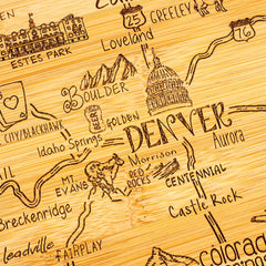 Explore the Destination Colorado Cutting Board by Totally Bamboo, measuring 14-1/2" x 10-3/4", featuring a beautifully illustrated wooden map of Colorado. This board showcases laser-engraved hand-drawn artwork of landmarks and cities, including Denver, Boulder, and Red Rocks. Roads, mountains, and attractions are artistically highlighted in a charming rustic style.