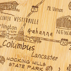 Introducing the Destination Ohio Cutting Board by Totally Bamboo, measuring 12" x 13-1/2". This laser-engraved wooden cutting board beautifully showcases various locations in Ohio, such as Columbus, Westerville, and Hocking Hills State Park. Designed for functionality and style, it features etched route numbers and landmarks that add a touch of elegance to any kitchen.