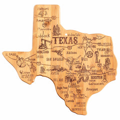 The Destination Texas Cutting Board, measuring 14" x 13-3/8" from Totally Bamboo, is crafted in the shape of Texas from premium bamboo. It features intricate engravings of cities such as Houston, Dallas, and San Antonio and is adorned with charming illustrations including a cowboy hat, an armadillo, and an oil rig.