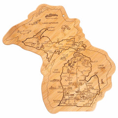 The Totally Bamboo Destination Michigan Cutting Board, measuring 16-3/4" x 16-1/2", is a distinctive wooden board shaped like the state of Michigan, featuring detailed engravings of its geography, lakes, and cities. The bamboo surface is further enhanced with illustrations of a ship, fish, and trees for added charm and utility.