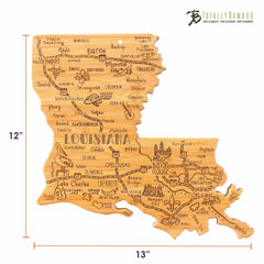 The Destination Louisiana Cutting Board by Totally Bamboo is a bamboo cutting surface in the shape of Louisiana, featuring laser-engraved artwork with city names and illustrated landmarks. Its dimensions are 13 inches wide and 12 inches tall.