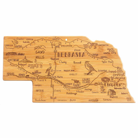 The Totally Bamboo Destination Nebraska Cutting Board, measuring 17-3/4" x 9", is a state-shaped board crafted from durable bamboo with laser-engraved artwork showcasing Nebraska's cities, including Omaha and Lincoln, along with its landmarks and local wildlife.