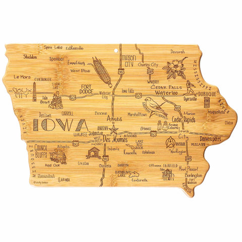 The Destination Iowa Cutting Board by Totally Bamboo is a bamboo cutting surface, measuring 15-1/2" x 10-1/4", shaped like the state of Iowa and featuring laser-engraved artwork that beautifully captures city names, iconic landmarks, wildlife, and activities.