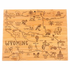 The Destination Wyoming Cutting Board by Totally Bamboo, measuring 11" x 14-1/4", showcases laser-engraved artwork of the state. It features detailed illustrations of cities such as Casper and Cheyenne, along with Yellowstone National Park and the region's diverse wildlife, offering both functionality and a rustic charm.