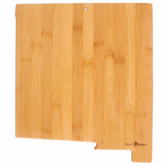 The "Destination New Mexico" cutting board from Totally Bamboo measures 11-3/4" x 13-1/2" and is rectangular in shape with a small notch on one side. It features a smooth, natural wood grain pattern, showcases laser-engraved artwork, and includes a hole near the top edge for hanging.