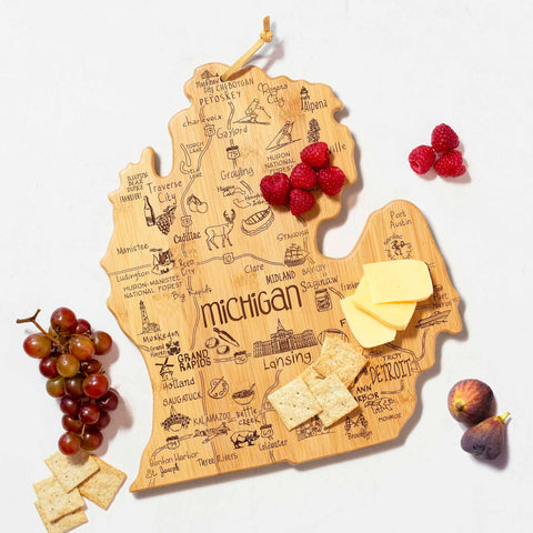 The Destination Michigan Mitten Cutting Board by Totally Bamboo is a unique bamboo piece shaped like the state of Michigan. It features laser-engraved city names and landmarks, and is decorated with clusters of grapes, raspberries, figs, crackers, and slices of cheese for a beautiful presentation. This cutting board measures 13-1/4" x 11-3/4".