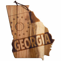 The Rock & Branch® Origins Series Georgia Cutting Board by Totally Bamboo is crafted from acacia wood and features laser-engraved artwork depicting "Georgia," a peach, and stars. It includes a leather loop at the top for easy hanging.