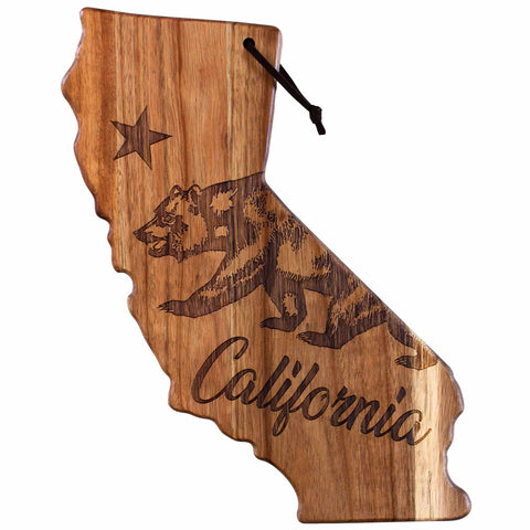 Introducing the Rock & Branch® Origins Series California Cutting Board by Totally Bamboo: an acacia wood cutting board shaped like California, featuring laser-engraved artwork of a bear and star with "California" below. A black cord is looped through the top for hanging, making it an ideal choice as a charcuterie board or a decorative wall piece.