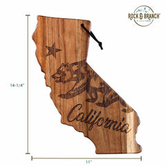 The Rock & Branch® Origins Series California Cutting Board by Totally Bamboo is shaped like the state of California and showcases laser-engraved artwork featuring a bear, a star, and the word "California." Constructed from acacia wood, this cutting board measures 14-1/4 inches in height and 11 inches in width and includes a handy strap at the top.