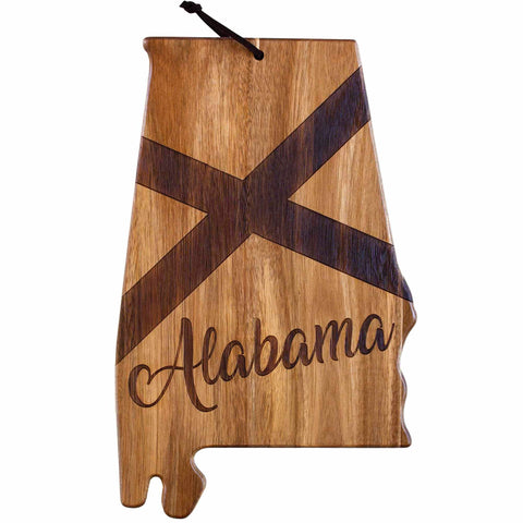 The Rock & Branch® Origins Series Alabama Cutting Board by Totally Bamboo is expertly crafted from acacia wood in the shape of Alabama, showcasing a dark cross pattern with "Alabama" elegantly laser-engraved on it. It includes a small string loop at the top for convenient hanging.