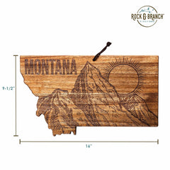 Discover the Rock & Branch® Origins Series Montana Cutting Board by Totally Bamboo, featuring state-themed artwork in the shape of Montana. Made from acacia wood, it exhibits an intricately engraved mountain scene with a sun and "Montana" etched at the top left. This piece measures 16 inches wide by 9.5 inches tall and includes a convenient cord for hanging.