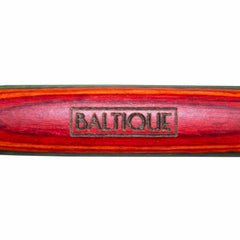 Close-up of a vibrant wooden object from the Baltique® Marrakesh Collection, with the brand name "Totally Bamboo" engraved in the center. Made from colored birch, it boasts rich red, brown, and green tones arranged in striking bands.