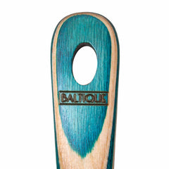 Close-up of the handle from the Totally Bamboo Baltique® Mykonos Collection Slotted Spoon, 12-1/2", featuring an oval cutout at the top with "Baltique" engraved on it. This colored birch handle exhibits a blue-green gradient design set against a natural wood background, echoing its elegant slotted spoon form.