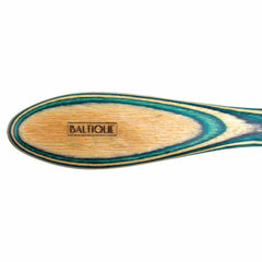 Close-up of a wooden spreader knife from the Baltique® Mykonos Collection, showcasing a distinctive turquoise and natural wood grain pattern. The brand name "Totally Bamboo" is engraved on the knife's oval-shaped head, crafted from colored birch.