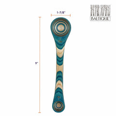 A Baltique® Mykonos Collection 2-in-1 Measuring Spoon, part of the Totally Bamboo brand, is crafted from colored birch and features multicolored layers of teal, blue, and natural wood tones. This spoon is 9 inches long and 1-7/8 inches wide with circular patterns on its top and bottom edges and proudly displays the "Baltique" logo in the upper right corner.