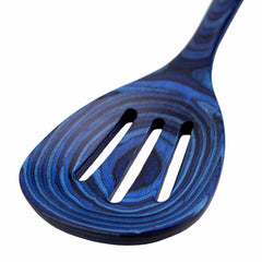 A close-up of the dark blue Baltique® Malta Collection Slotted Spoon, measuring 12-1/2 inches and crafted by Totally Bamboo from colored birch, features a swirling pattern. This elegant kitchen utensil includes three slots for efficient liquid draining, with its handle extending from the top right corner of the image.