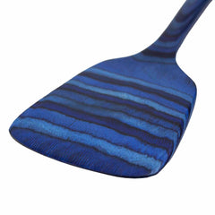 A close-up of the 12-1/2" Baltique® Malta Collection Spatula by Totally Bamboo highlights its blue hues with dark blue stripes, smooth flat surface, and rounded edges, making it ideal for use with non-stick cookware.