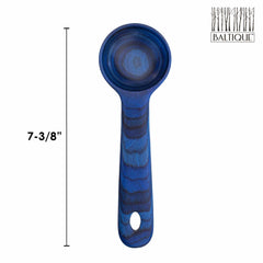 A blue wooden spoon with a round tip is displayed next to a measurement line showing it is 7-3/8 inches long. This Malta Coffee Scoop from the Baltique® Malta Collection by Totally Bamboo features the word "Baltique" in the top right corner, accompanied by a stylized tree logo.