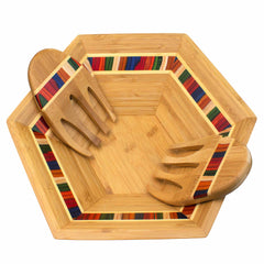 The Baltique® Marrakesh Collection Salad Bowl & Salad Hands Set by Totally Bamboo features a hexagonal wooden bowl with a vibrant striped inlay design around the edges. Two wooden salad forks, or "salad hands," elegantly rest inside, their handles decorated with matching colorful stripes.