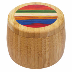 A round wooden salt cellar by Totally Bamboo, part of the Baltique® Marrakesh Collection, features a smooth finish and a lid decorated with vibrant horizontal stripes in shades of red, orange, yellow, green, blue, and purple. It has an 8-ounce capacity.