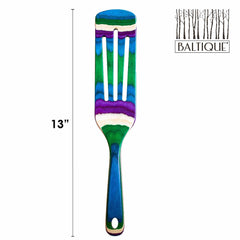 The 13-inch spatula from the Totally Bamboo "Baltique® Mumbai Collection" is a vibrant kitchen tool featuring a striking mix of blue, green, and purple stripes. The word "Baltique" is elegantly displayed in the top right corner. This colorful utensil is safe for non-stick cookware, combining style and functionality beautifully against a white background.