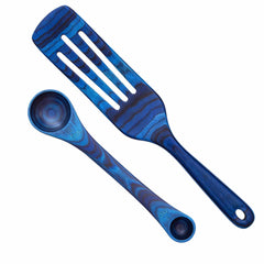 A stunning set from the Baltique® Malta Collection by Totally Bamboo, featuring a vibrant blue wooden slotted spatula and a 2-in-1 Measuring Spoon adorned with a unique wavy pattern, is elegantly showcased on a pristine white background.