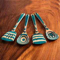 From the Baltique® Mykonos Collection by Totally Bamboo, this exquisite 4-piece cooking utensil set showcases four wooden tools adorned with turquoise and natural wood stripes, elegantly presented on a wooden table. The set comprises a slotted spatula, a spoon, a ladle, and a spatula with a circular cutout.