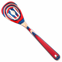 The Baltique® Old Glory Collection Slotted Spoon by Totally Bamboo, measuring 12-1/2 inches, features vibrant patterns of red, blue, and white on colored birch. Its distinctive design includes a smooth, rounded handle and a wide, flat slotted head with a hole in the center.