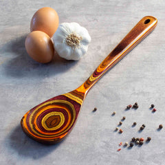 The Baltique® Poconos Collection Cooking Spoon from Totally Bamboo, adorned in autumnal hues, cradles spices and garlic while being perfectly safe for use with non-stick cookware.