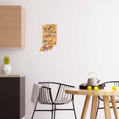 In a modern kitchen, a small wooden table is paired with black chairs. Lemons, a teapot, and cups are arranged on the table. A wooden decorative map adorns the white wall, while atop a wooden cabinet sits a geometric vase next to an Indiana Cutting Board with Artwork by Fish Kiss™ from Totally Bamboo.