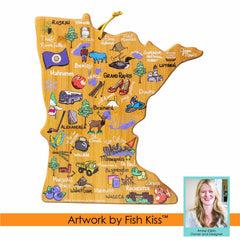 The "Minnesota Cutting Board with Artwork by Fish Kiss™," created by Totally Bamboo, features an illustrated map of Minnesota showcasing cities and landmarks such as Minneapolis, Duluth, and Rochester. Decorated with images of loons and pine trees, this piece includes the distinctive Fish Kiss artwork. An inset photo highlights Anne Klein next to a Fish Kiss logo.