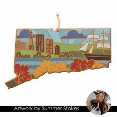 The Connecticut Cutting Board with Artwork by Summer Stokes from Totally Bamboo features a state-shaped design highlighting city buildings, a sailing ship, and a tree-lined river. This vibrant artwork showcases hues of blue, green, orange, and brown. A small circular inset on the board depicts a smiling woman and her dog.