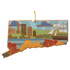 A Connecticut-shaped decorative piece featuring Summer Stokes' vibrant illustrations of buildings, a ship, and trees, comes with a gold string for hanging. This unique design is part of the Totally Bamboo brand's Connecticut Cutting Board collection.