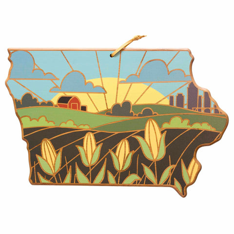 The Iowa Cutting Board with Artwork by Summer Stokes, offered by Totally Bamboo, is an ideal addition to any space. Shaped like Iowa and crafted from a bamboo cutting surface, it vividly portrays a picturesque farm landscape complete with cornfields, a barn, and a city skyline bathed in the soft colors of sunrise.