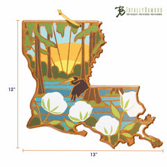 This Louisiana Cutting Board with Artwork by Summer Stokes is crafted from a premium bamboo surface, featuring intricate details like cypress trees, a sunset, and cotton plants. An elegant great egret stands on the water. Measuring 12x13 inches, it proudly showcases its "Totally Bamboo" branding in the corner.