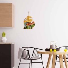 A modern kitchen with a wooden table and black chairs, highlighted by the Michigan Mitten Cutting Board from Totally Bamboo and adorned with lemons, is enhanced by vibrant artwork featuring Summer Stokes on a white wall. Wooden cabinetry and geometric plant pots create harmony in the background, while the bamboo cutting board adds an organic touch.