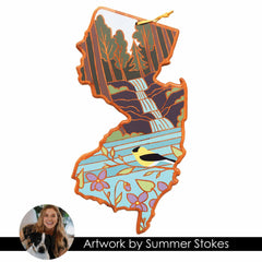 The New Jersey Cutting Board with Artwork by Summer Stokes from Totally Bamboo features illustrated artwork of a waterfall, trees, bird, and flowers in the shape of New Jersey. A circular photo at the bottom shows a person with a dog and is labeled "Summer Stokes Artwork," making it ideal for those who appreciate artistic state-shaped cutting boards.