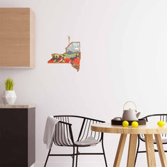 The modern kitchen interior showcases a round wooden table, black chairs, and a white teapot. An artwork of New York by Summer Stokes elegantly adorns the wall, enhancing the minimalist decor that also features a Totally Bamboo cutting board on the wooden cabinet and a geometric vase with a plant.