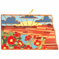 Summer Stokes's stunning artwork, featured on the North Dakota Cutting Board by Totally Bamboo, showcases a stylized landscape with vibrant red flowers, rolling hills, and a sunlit river.