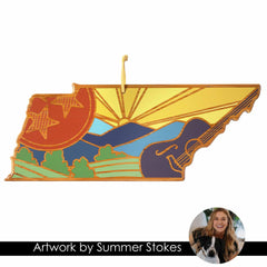 The Tennessee Cutting Board with Artwork by Summer Stokes from Totally Bamboo is a stunning wooden art piece crafted into the shape of Tennessee. It showcases vibrant designs featuring a sun, rolling hills, two stars, a guitar, and includes a small photograph of an artist and her dog with the text: "Artwork by Summer Stokes.