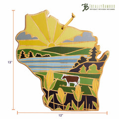 Introducing the Wisconsin Cutting Board with Artwork by Summer Stokes from Totally Bamboo. This wooden cutting board is expertly designed in the shape of Wisconsin, featuring a stunning depiction of a vibrant sunrise, fields, a cow, and trees by renowned artist Summer Stokes. Measuring 13 inches in height and 12 inches in width, it proudly displays the Totally Bamboo logo at the top right corner.