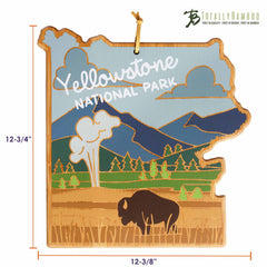 A Yellowstone Cutting Board by Totally Bamboo, designed by Summer Stokes, is shaped like Yellowstone National Park and features UV-printed text "Yellowstone National Park." It includes engraved illustrations of geysers, mountains, and a bison on a bamboo cutting surface. The dimensions are 12-3/8" by 12-3/4".