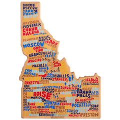 This charming Idaho Cutting Board from Totally Bamboo, featuring artwork by Wander on Words™, showcases a whimsical illustrated map with vibrant hand-drawn names of cities and landmarks like Boise and Coeur d'Alene. The design is set against a light wooden texture, making it ideal for those who enjoy wordplay and exploration.